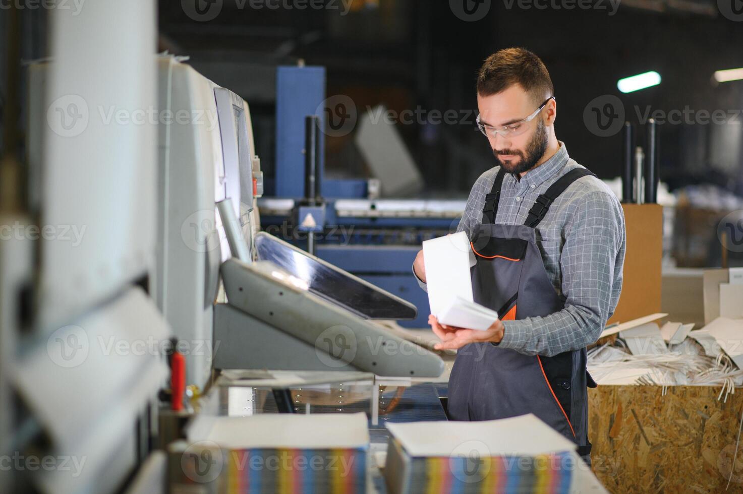 printing house, experimented technician works on UV printer. Production work photo