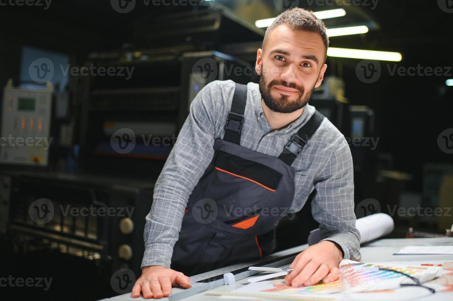 Graphic engineer or worker checking imprint quality in modern print shop photo