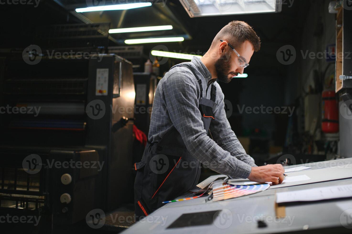 Graphic engineer or worker checking imprint quality in modern print shop photo