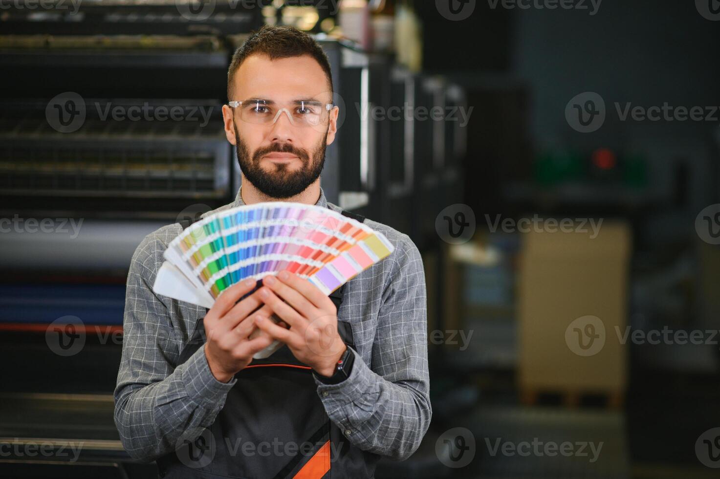 Typographer standing with color swatches at the printing manufacturing photo