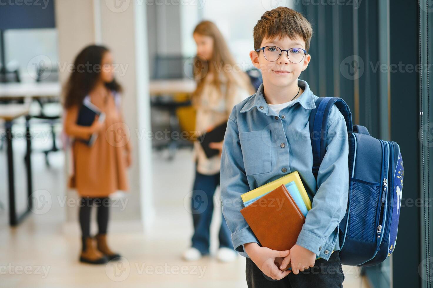 Schoolboy with schoolbag and books in the school. Back to school photo