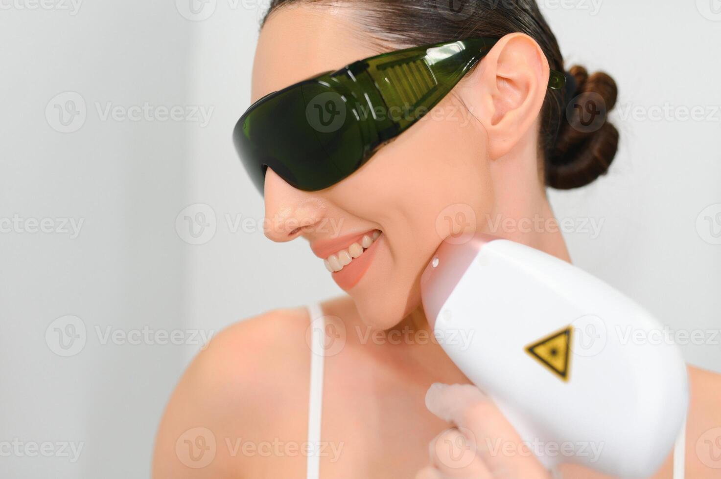 Young woman making body hair removal laser depilation in beauty center photo