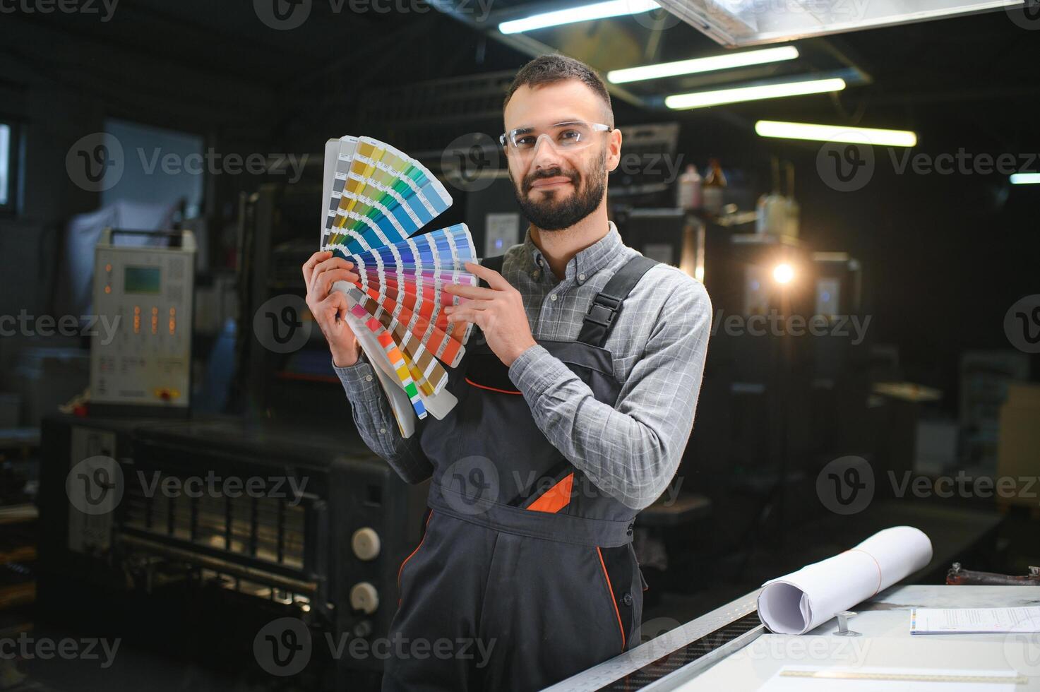 Graphic engineer or worker checking imprint quality in modern print shop photo