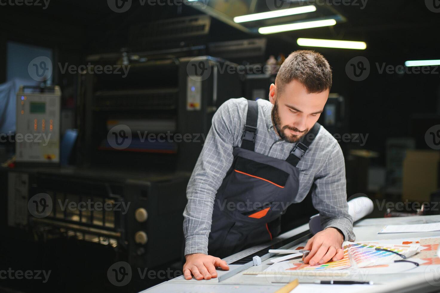 Graphic engineer or worker checking imprint quality in modern print shop photo