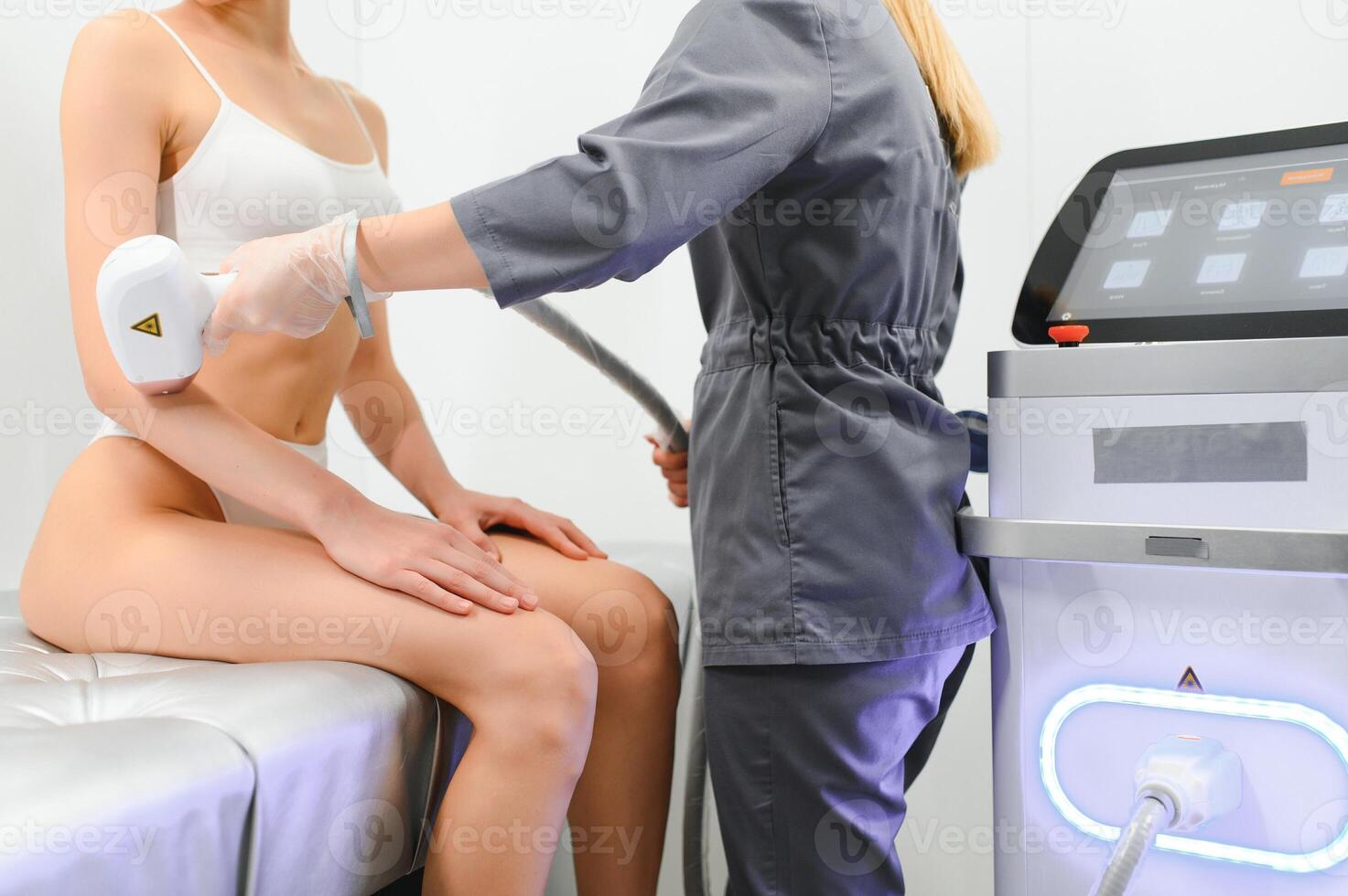 Young woman making body hair removal laser depilation in beauty center photo