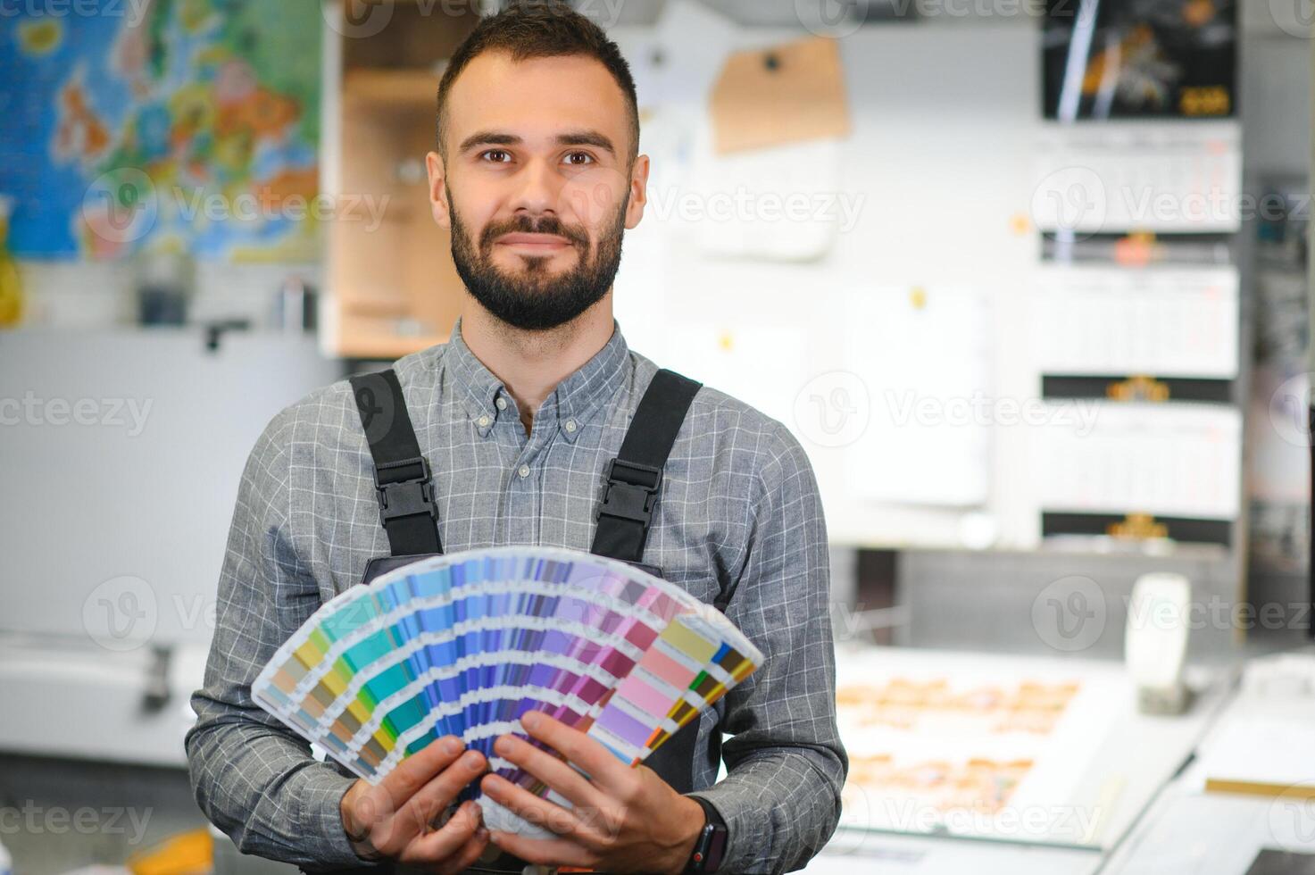 Typographer standing with color swatches at the printing manufacturing photo