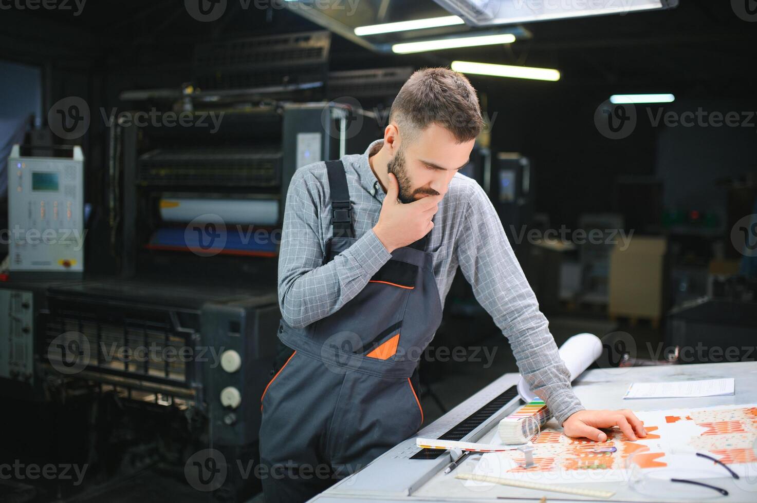 Graphic engineer or worker checking imprint quality in modern print shop photo