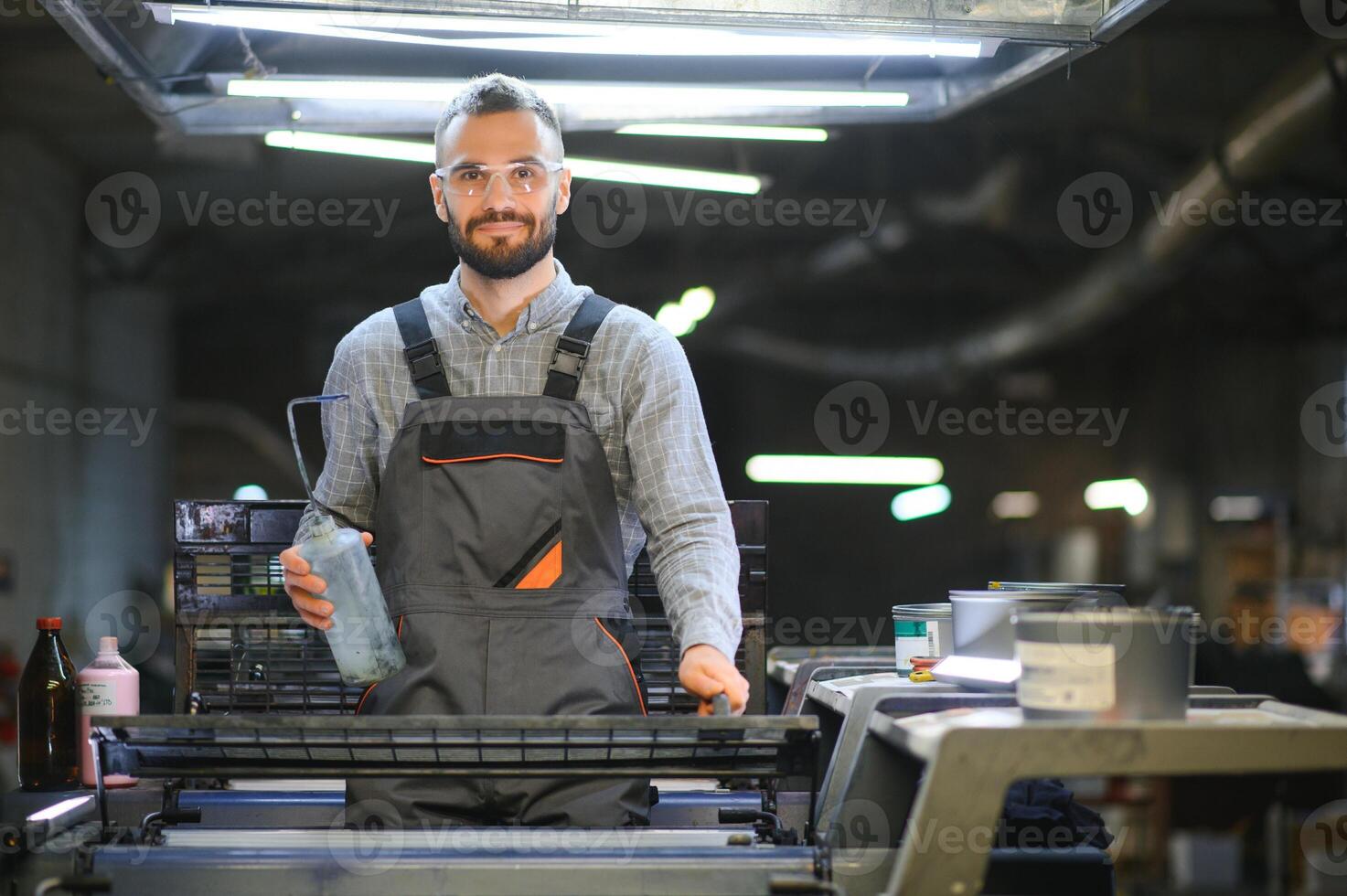 printing house, experimented technician works on UV printer. Production work photo