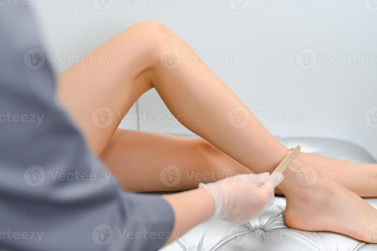 close-up of young caucasian slender woman getting laser epilation in beauty salon. photo