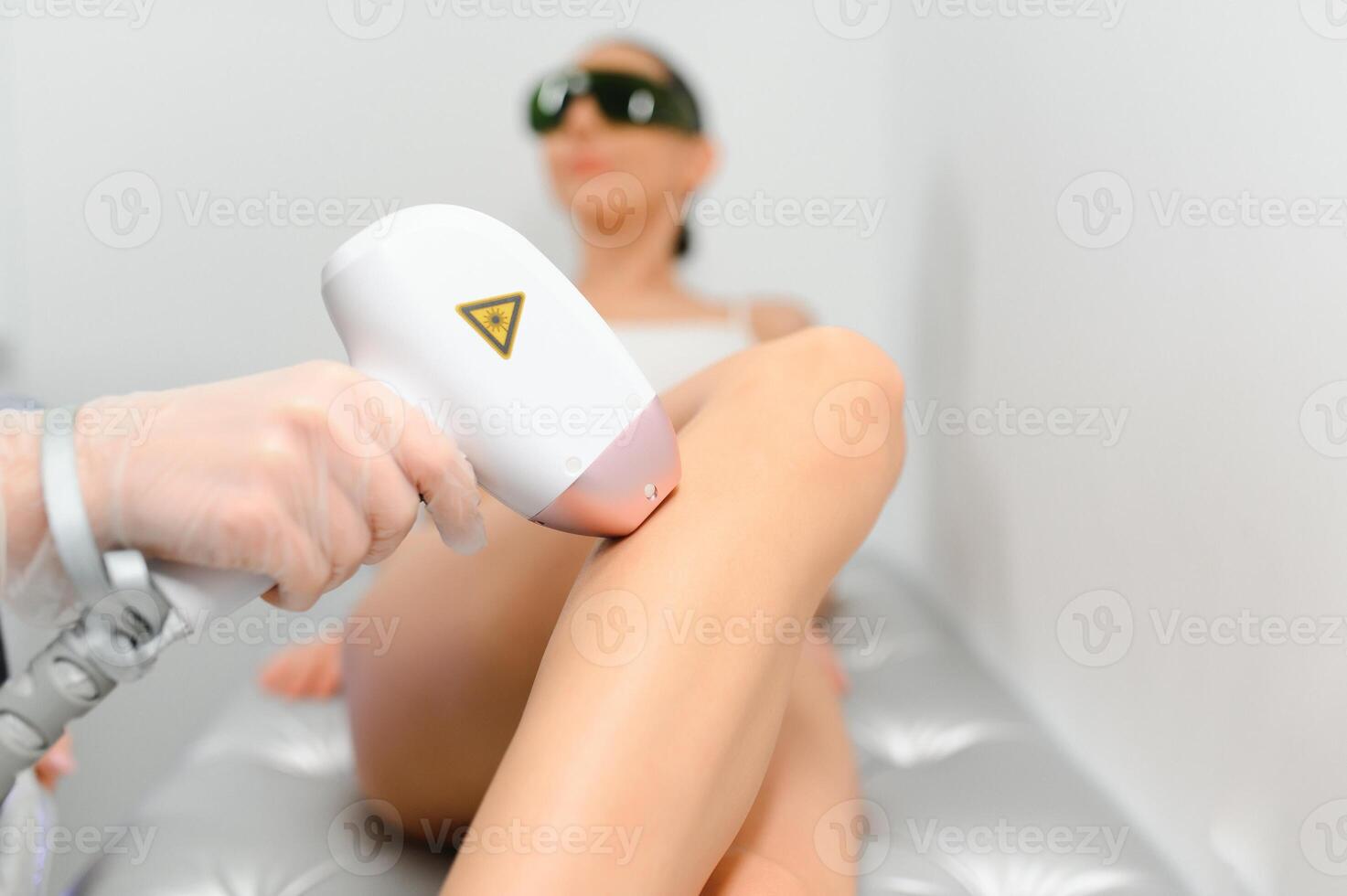 close-up of young caucasian slender woman getting laser epilation in beauty salon. photo