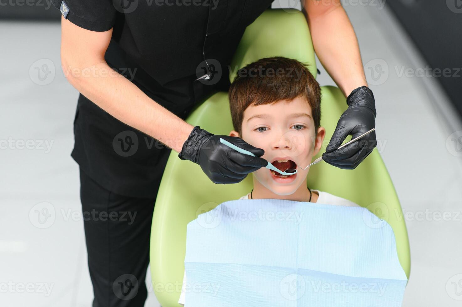 Close-up of little boy opening his mouth during dental checkup photo