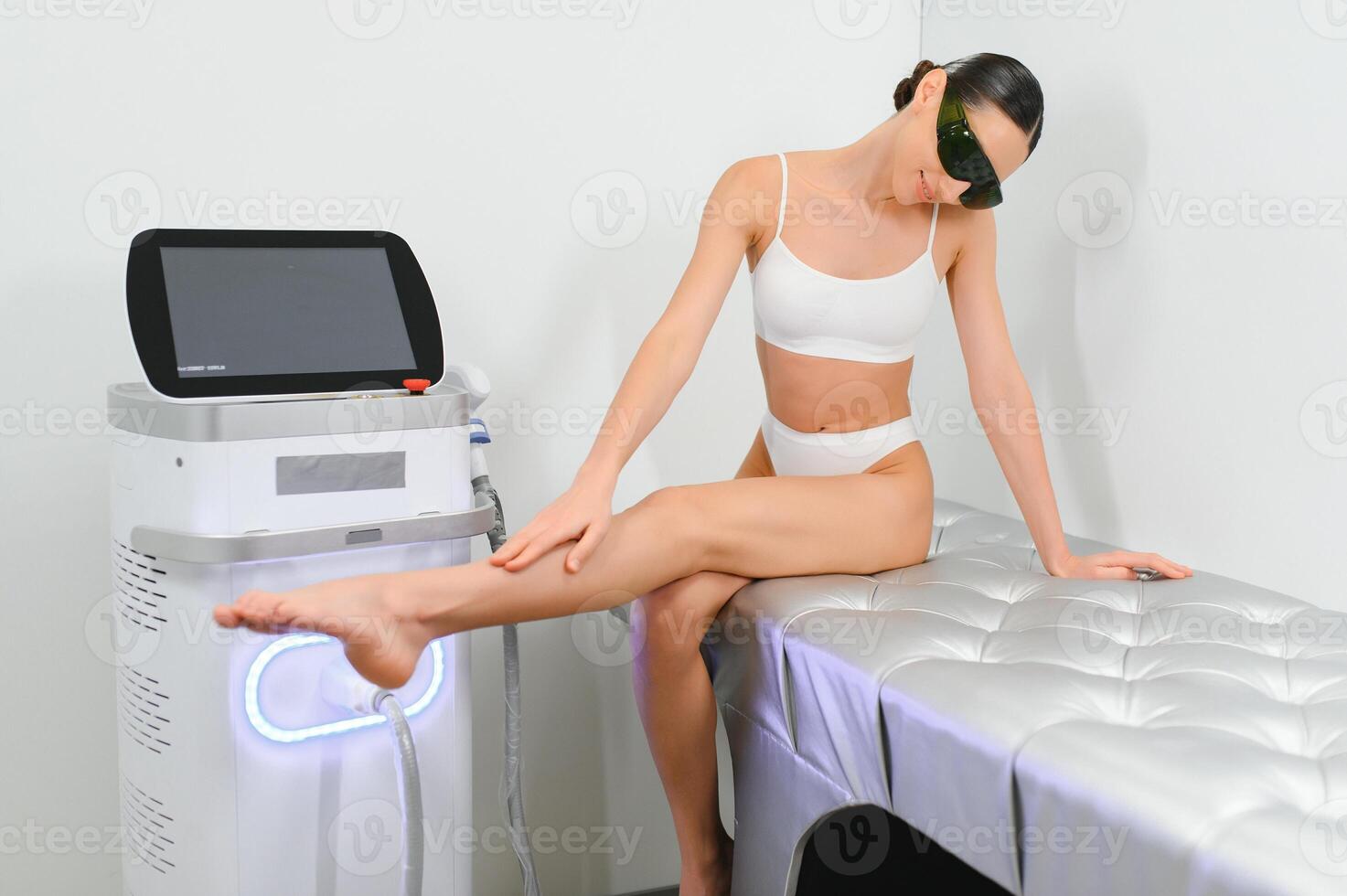 Happy young woman after laser hair removal. A woman near a laser depilation machine photo