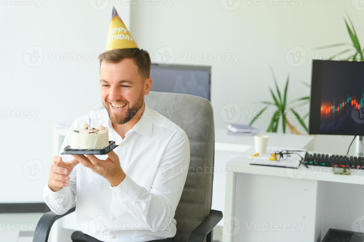 joven empresario celebrando cumpleaños solo en oficina foto