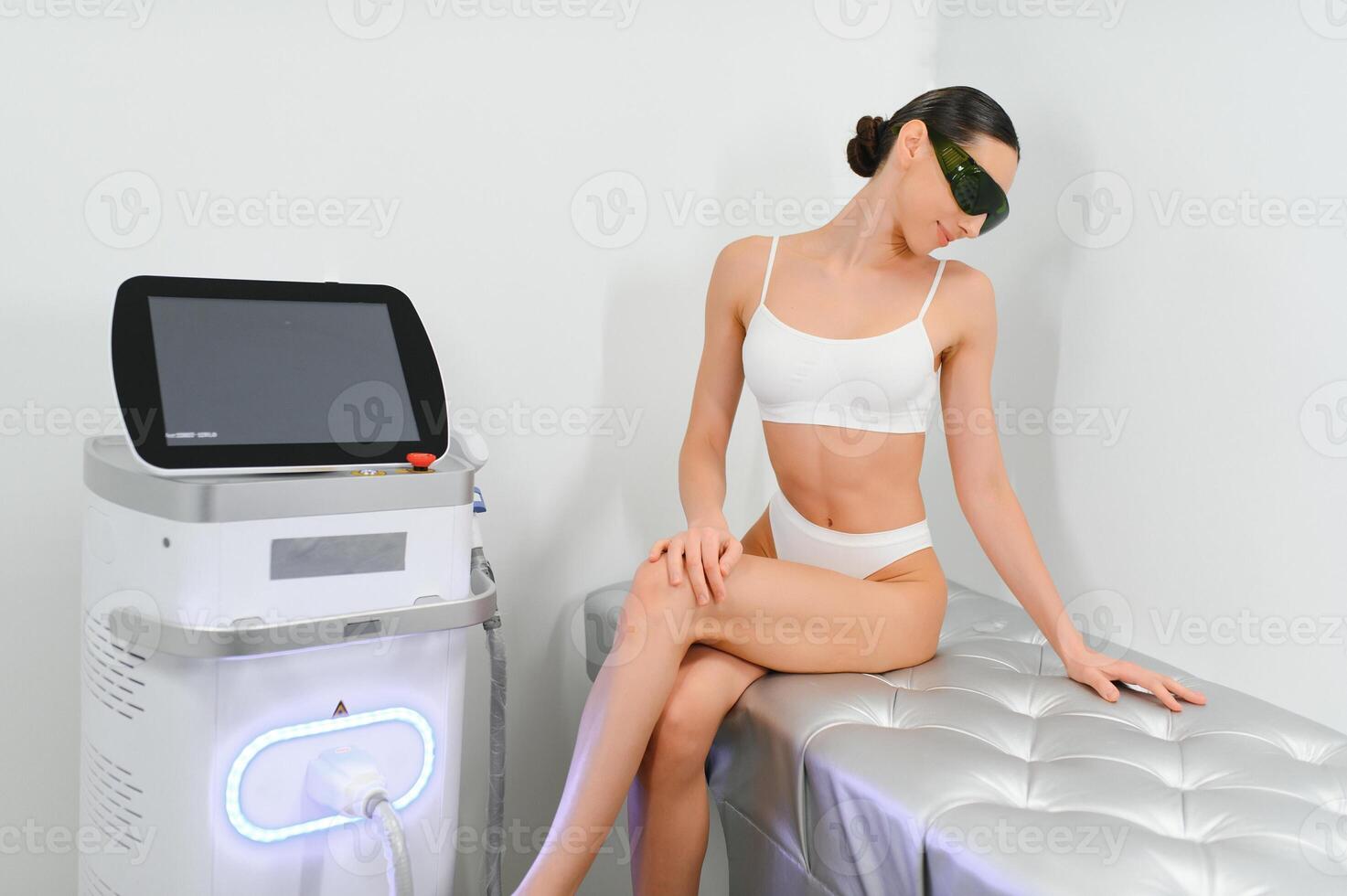 Happy young woman after laser hair removal. A woman near a laser depilation machine photo