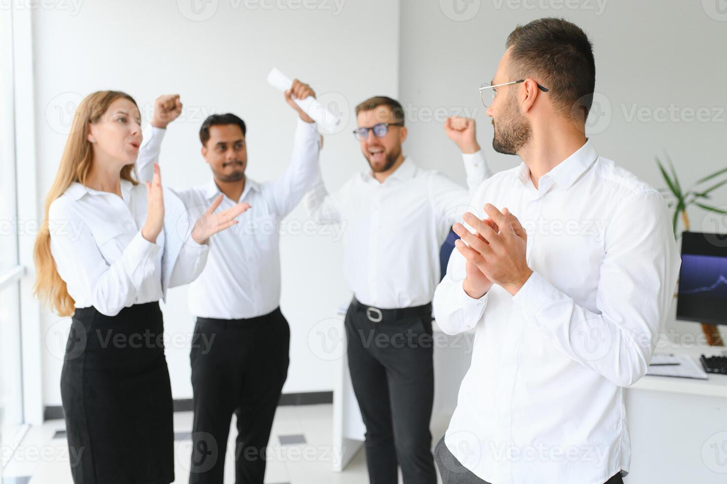 Portrait Of Young Handsome Businessman In Office With Colleagues in The Background photo