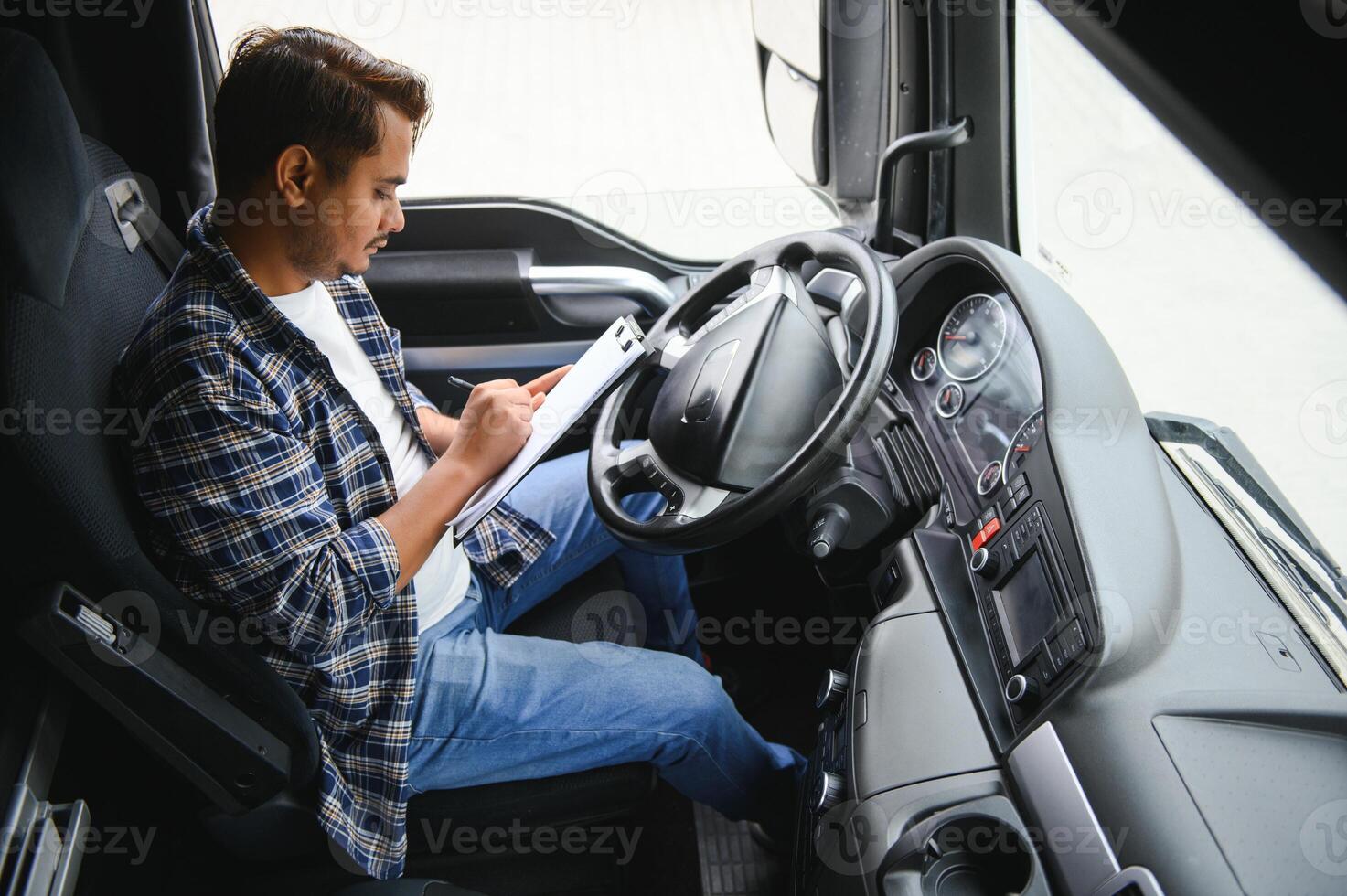 Portrait of a young handsome Indian truck driver. The concept of logistics and freight transportation. photo