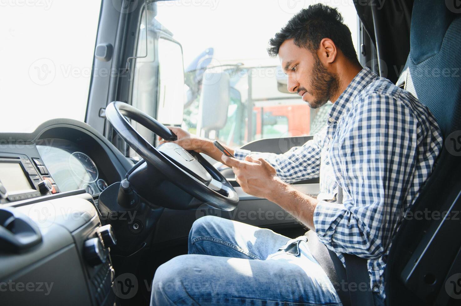 joven hermoso indio hombre utilizando inteligente teléfono en su camión. foto