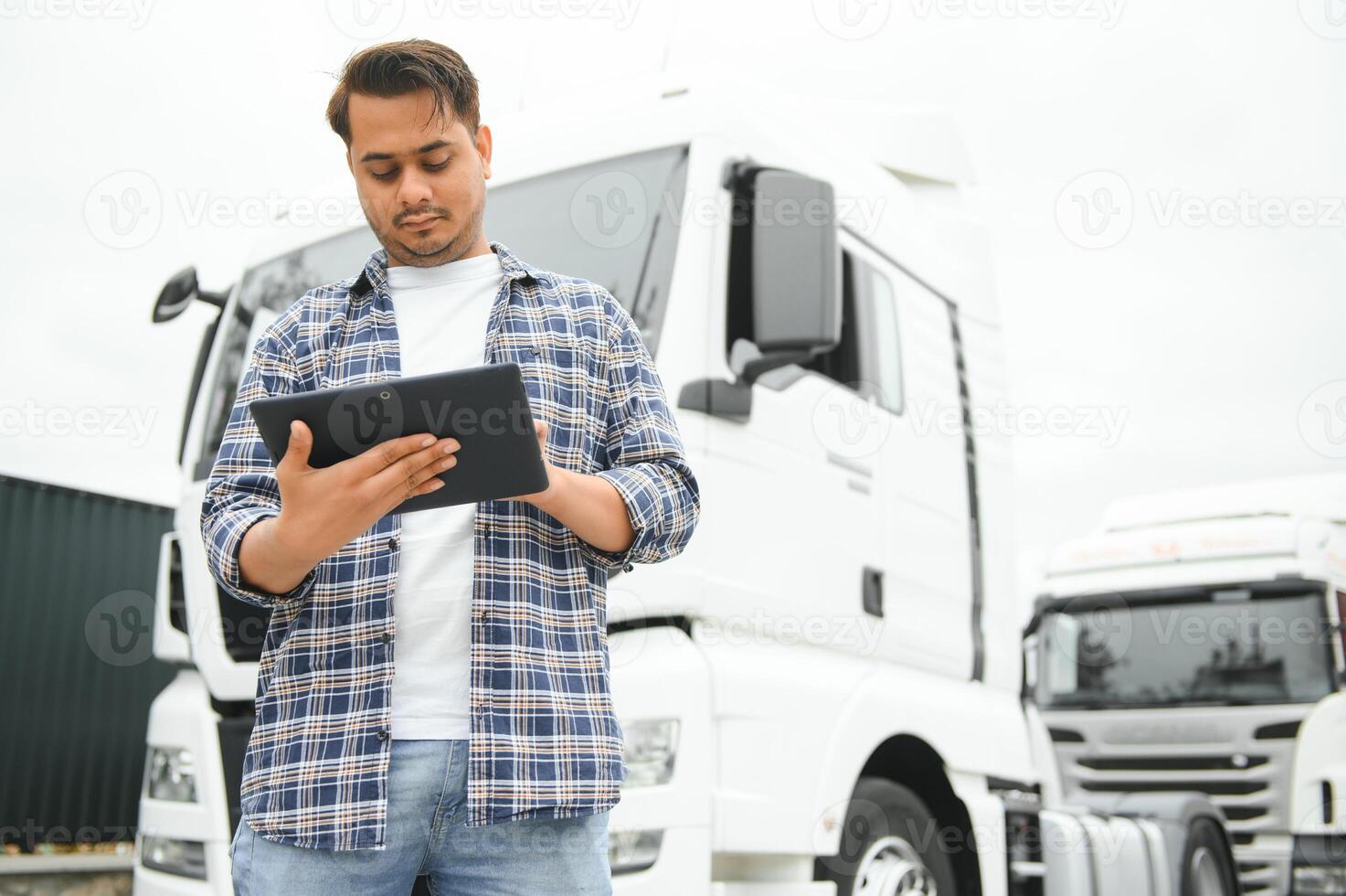 Happy indian courier using tablet in the van . High quality photo