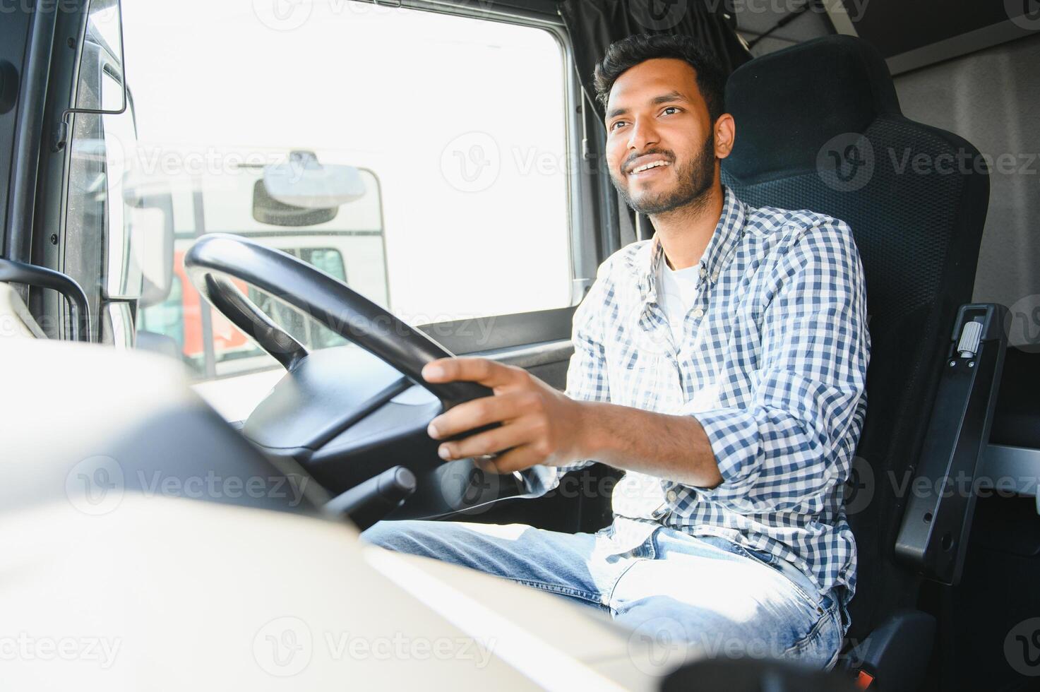 Happy professional truck driver driving his truck. Copy space. photo