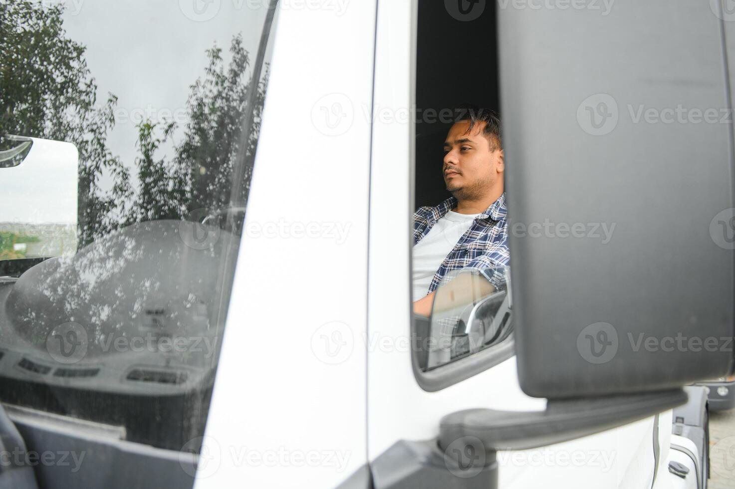 Portrait of a young handsome Indian truck driver. The concept of logistics and freight transportation. photo