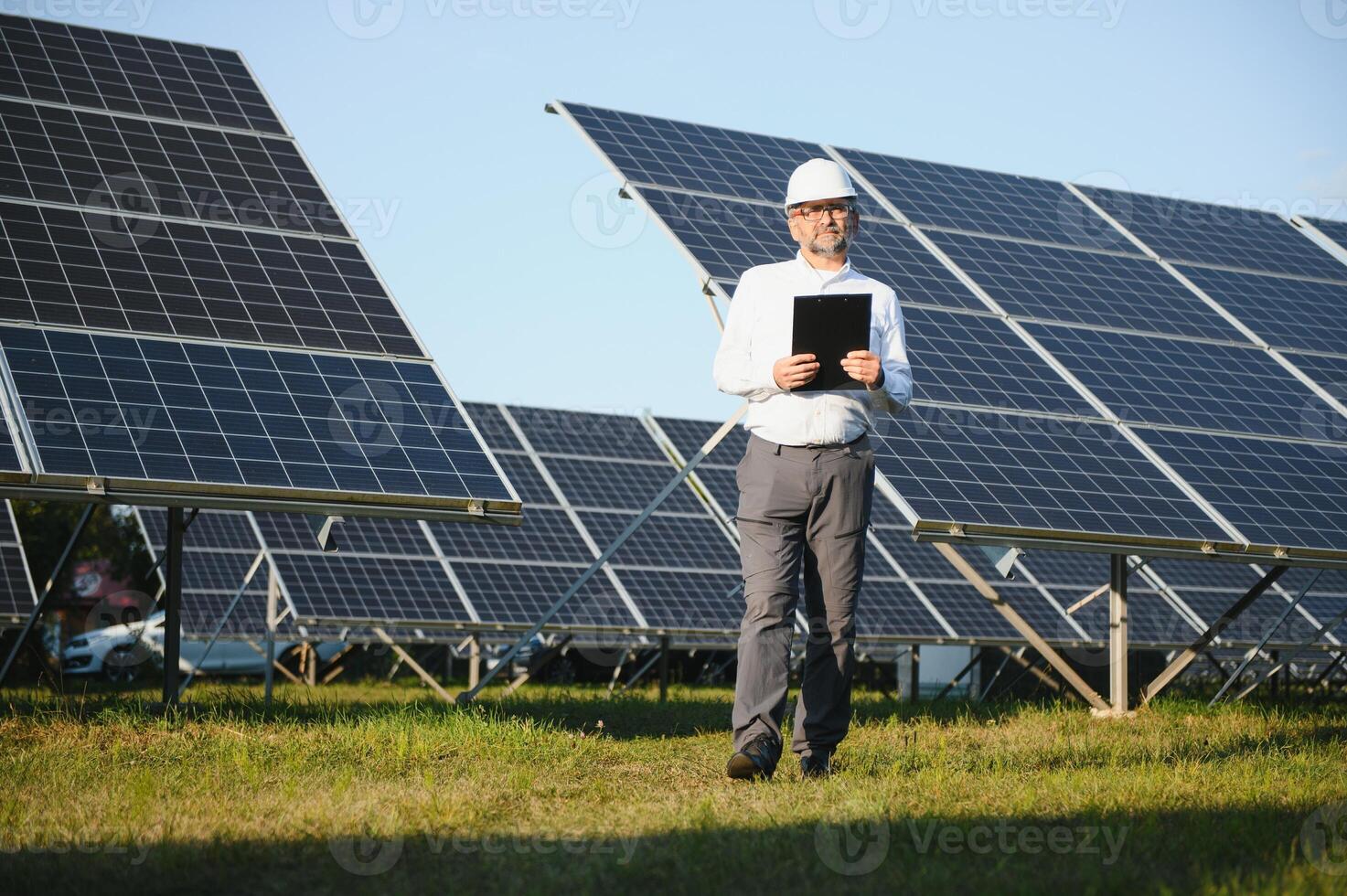 Solar power plant. Man standing near solar panels. Renewable energy photo