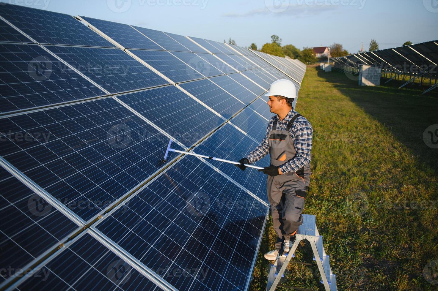 Indian worker cleaning solar panels photo