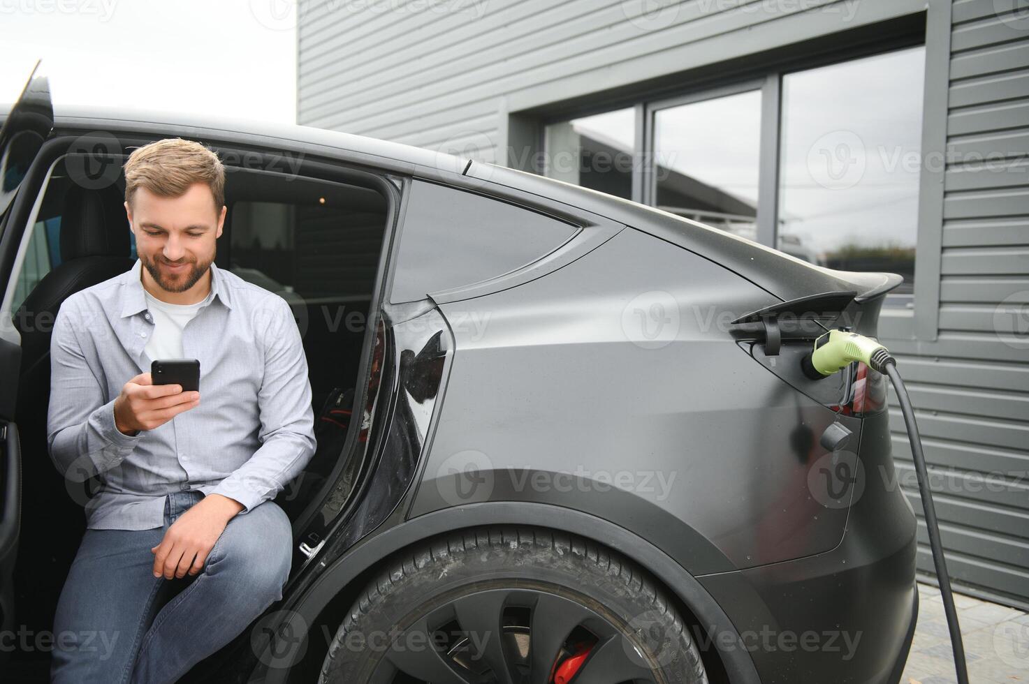 a man charges an electric car photo