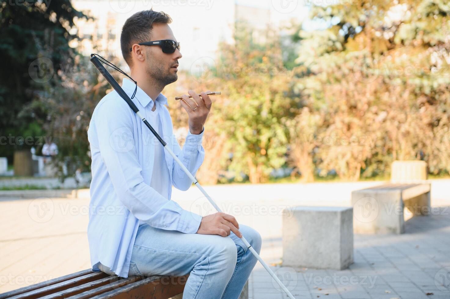 Blinded man waiting for bus at a bus station photo