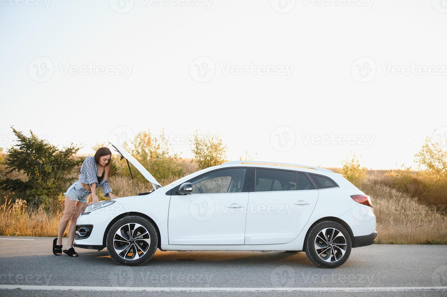 Beautiful sexy woman near a broken car. Confused woman does not know what to do photo