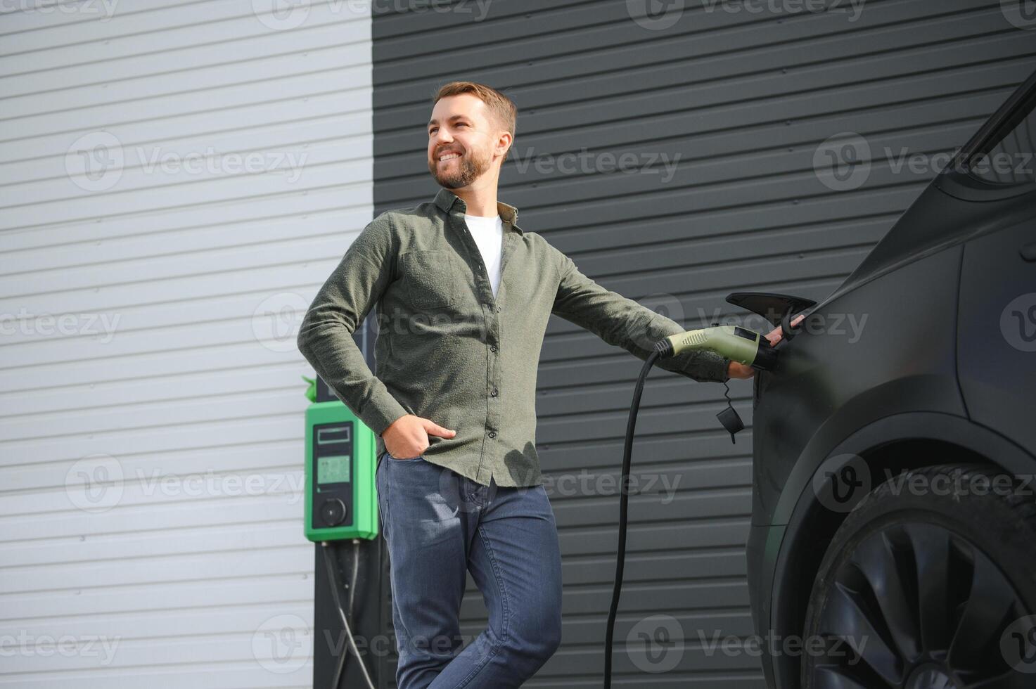 a man charges an electric car photo