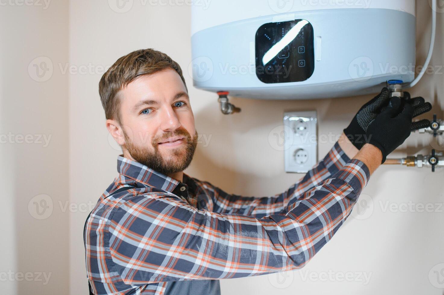 Professional engineer installing a natural gas boiler at home, he is checking the pipes photo