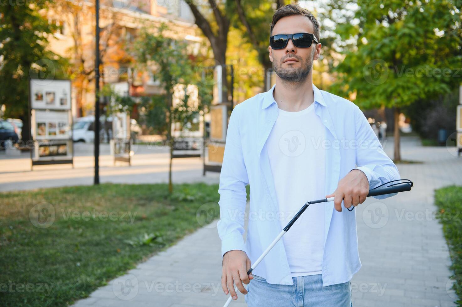 Blind man. Visually impaired man with walking stick, photo