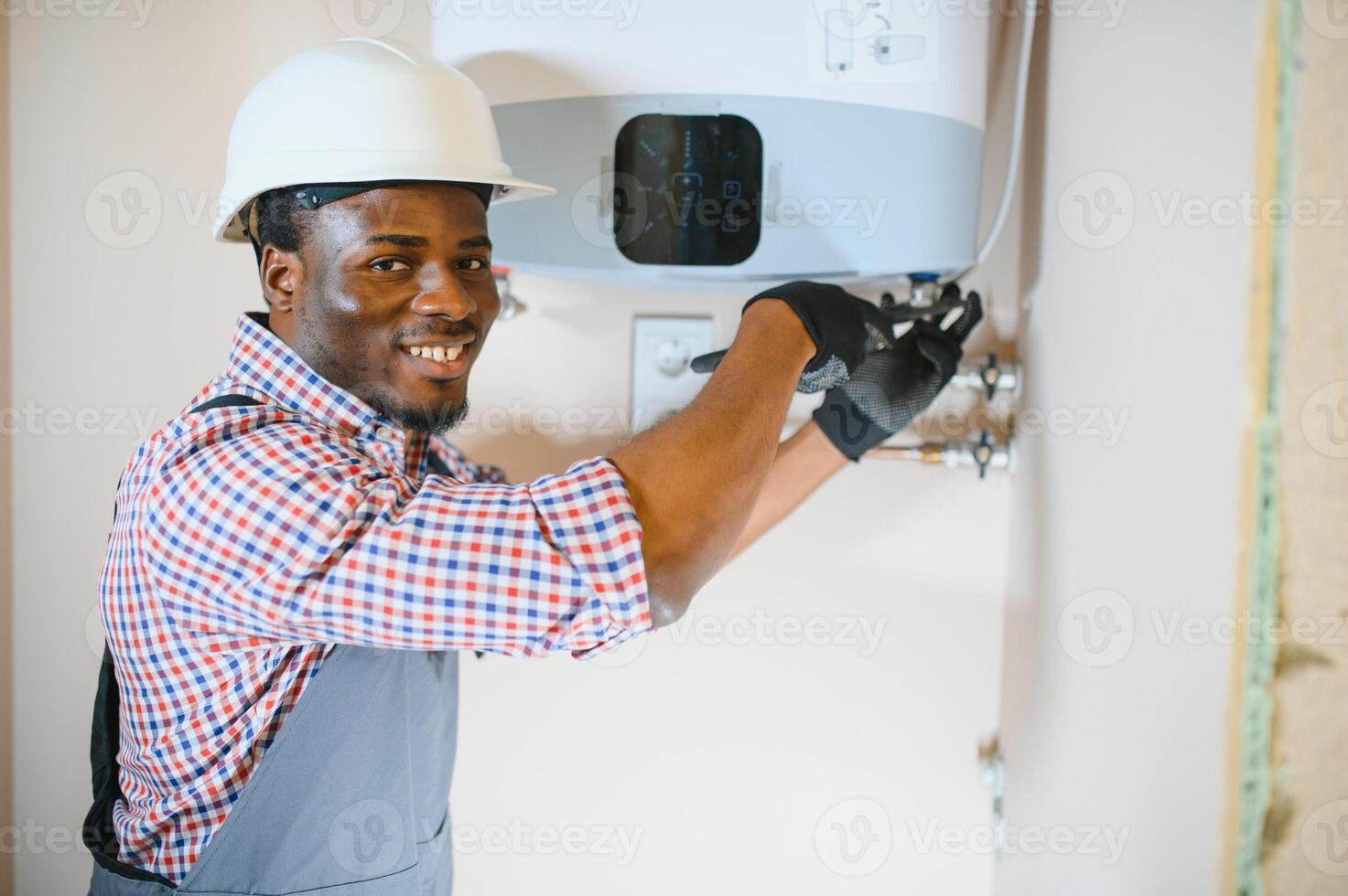 Professional engineer installing a natural gas boiler at home, he is checking the pipes photo
