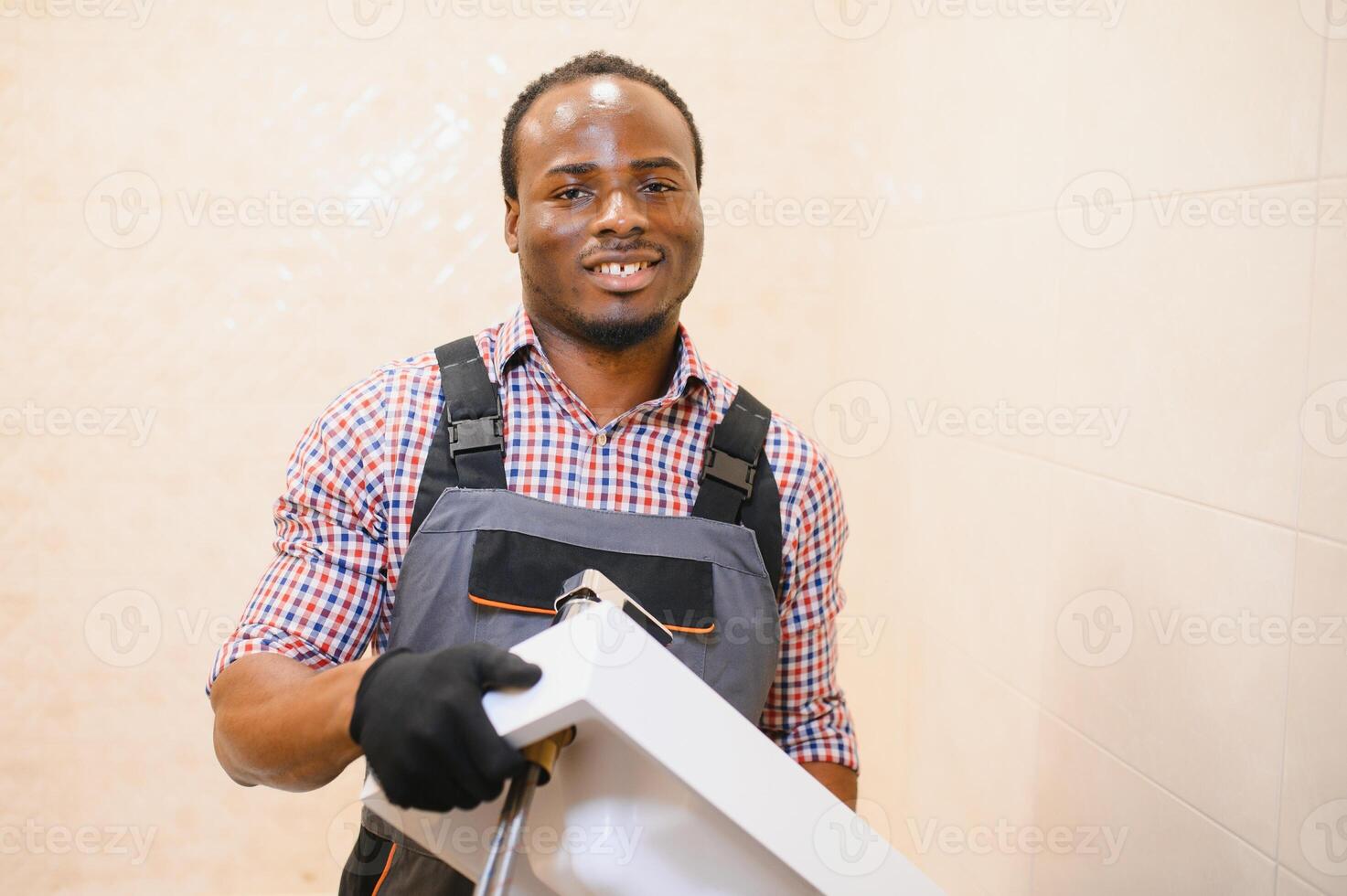 lado ver de joven africano masculino fontanero fijación lavabo en baño foto