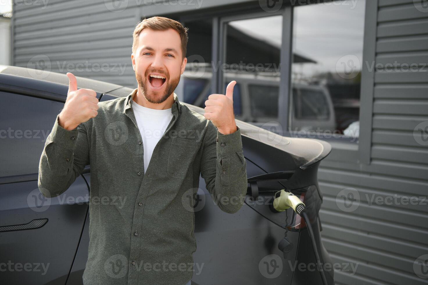 hombre cargando eléctrico coche por el casa foto