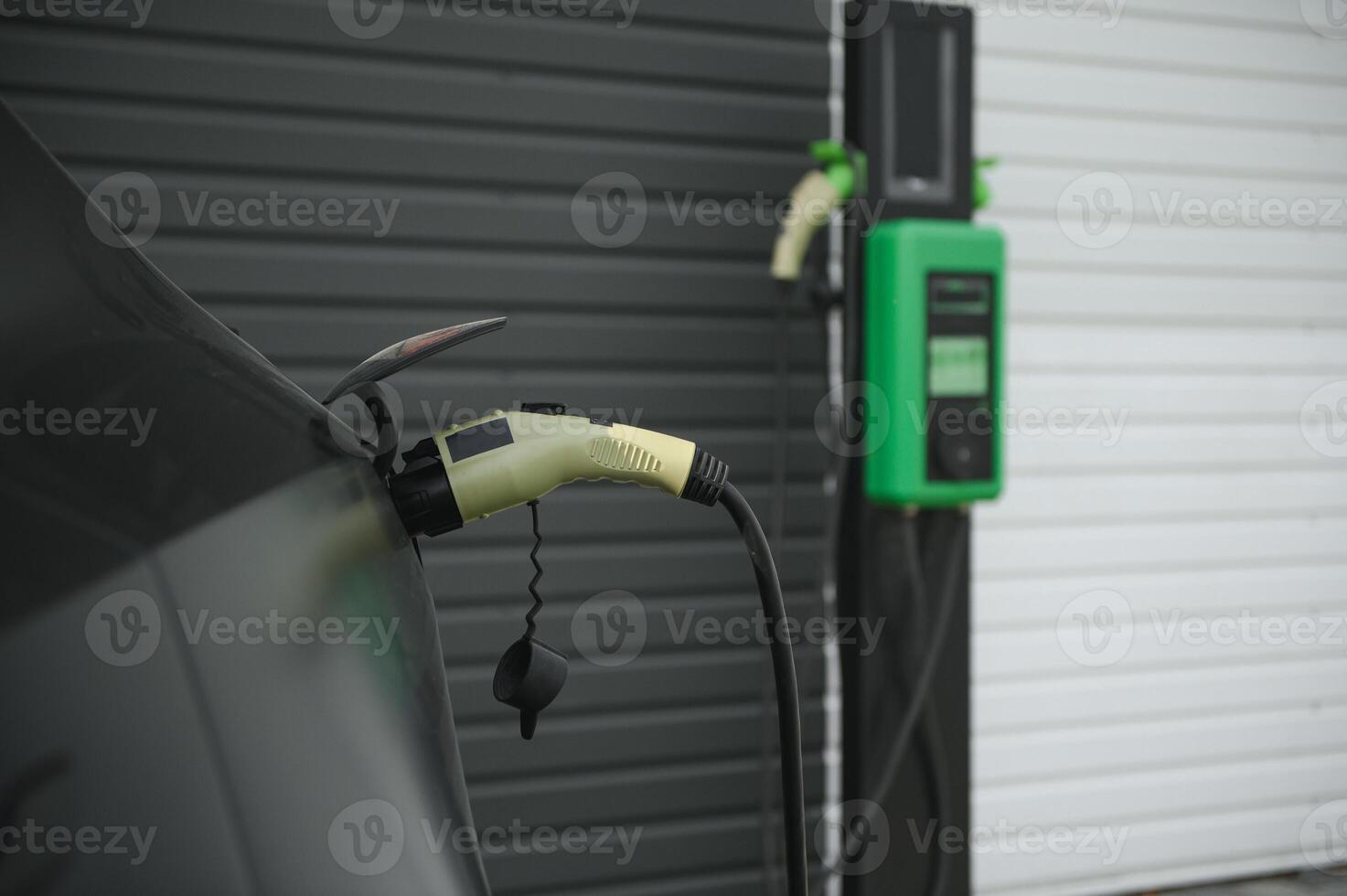 Power cable pump plug in charging power to electric vehicle EV car photo