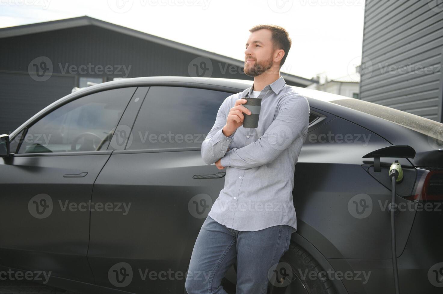 a man charges an electric car photo