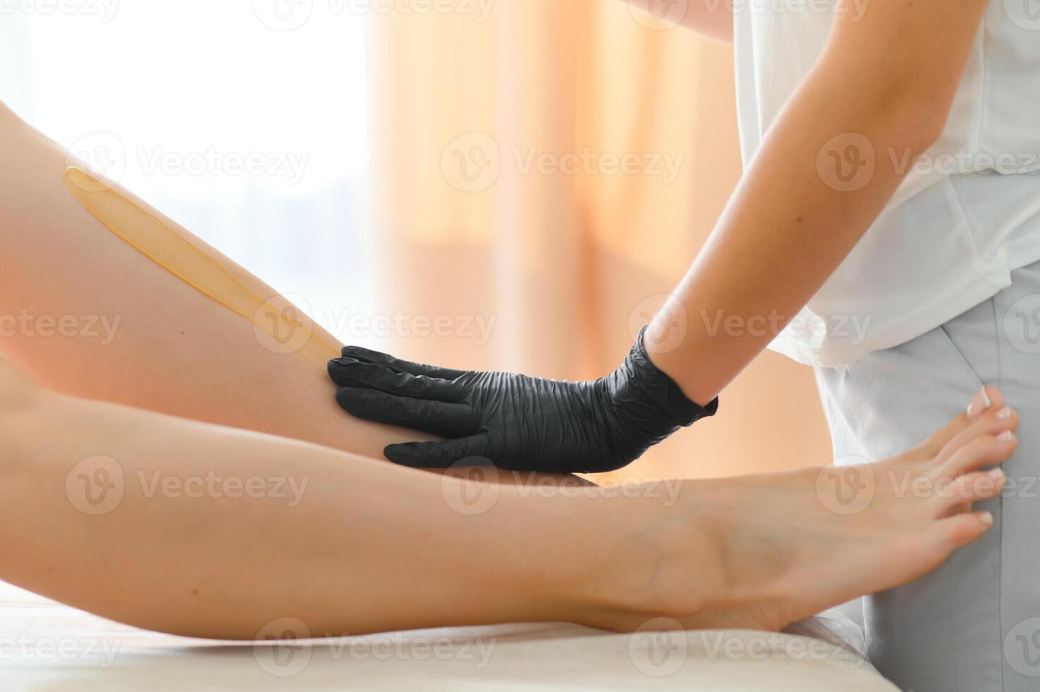 Sugaring epilation skin care with liquid sugar at legs close-up. Beauty and cosmetology concept. photo