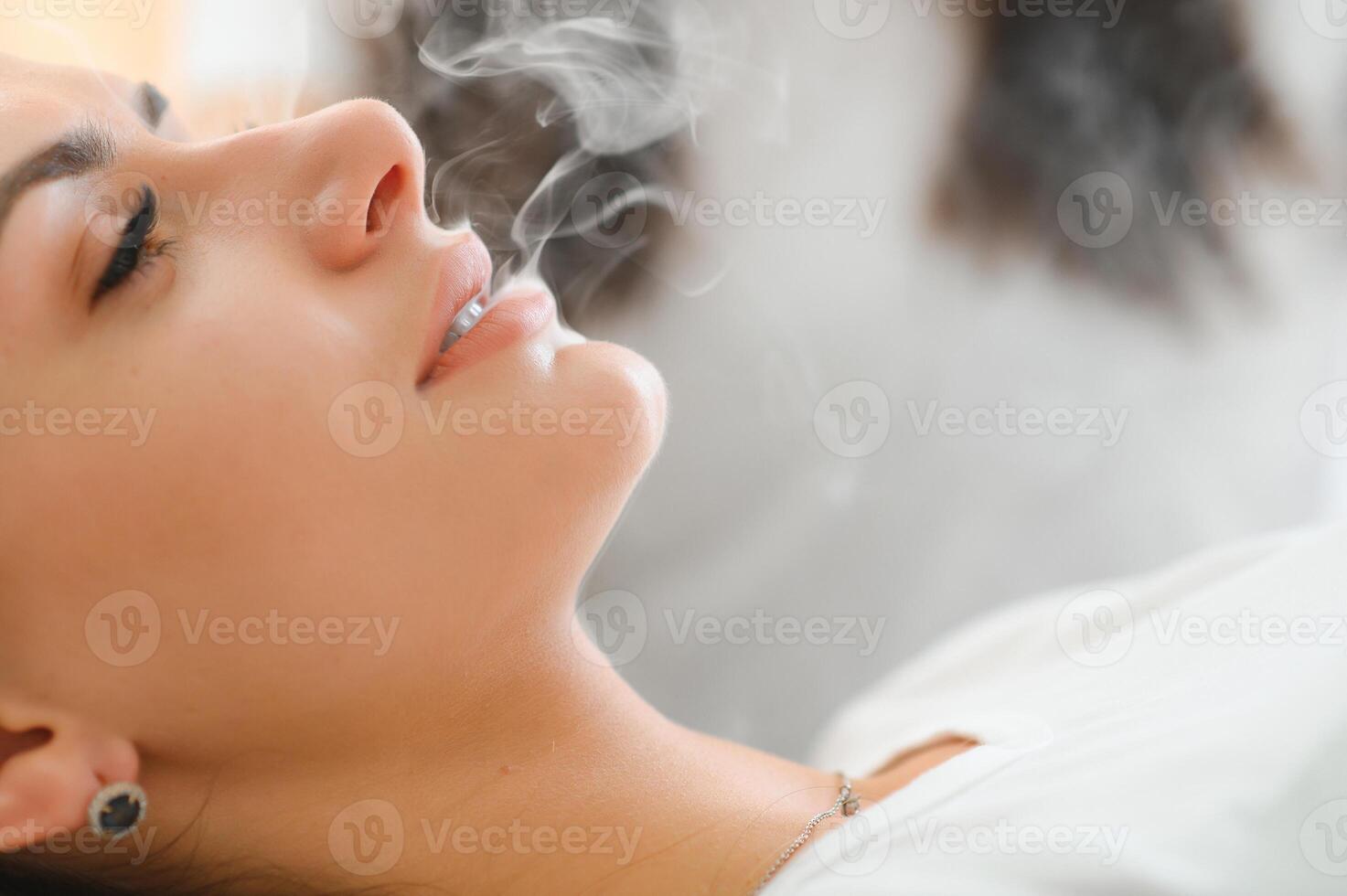 Woman smoking, close up on smoke and mouth photo