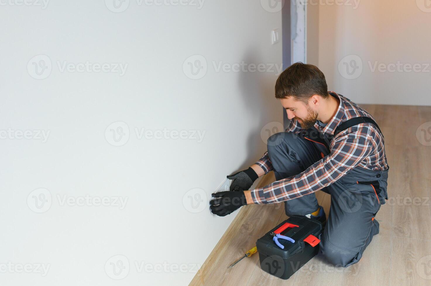 Electrician installs decorative frame on electric and TV sockets photo