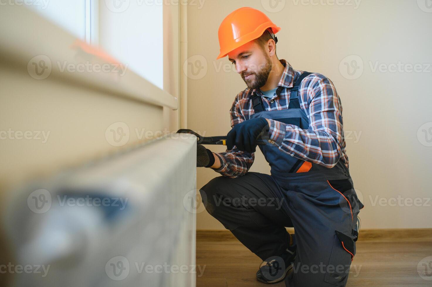 heating system installation and maintenance service. plumber installing radiator photo