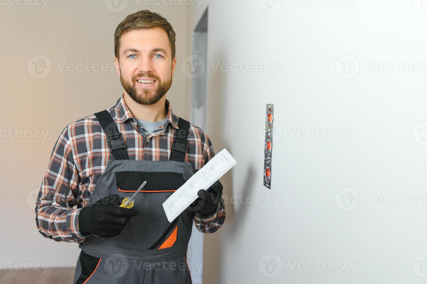 Electrician installs decorative frame on electric and TV sockets photo