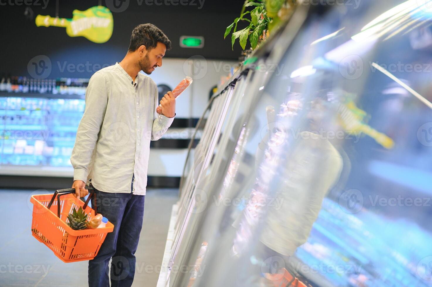 Portrait of indian man purchasing in a grocery store. Buying grocery for home in a supermarket photo