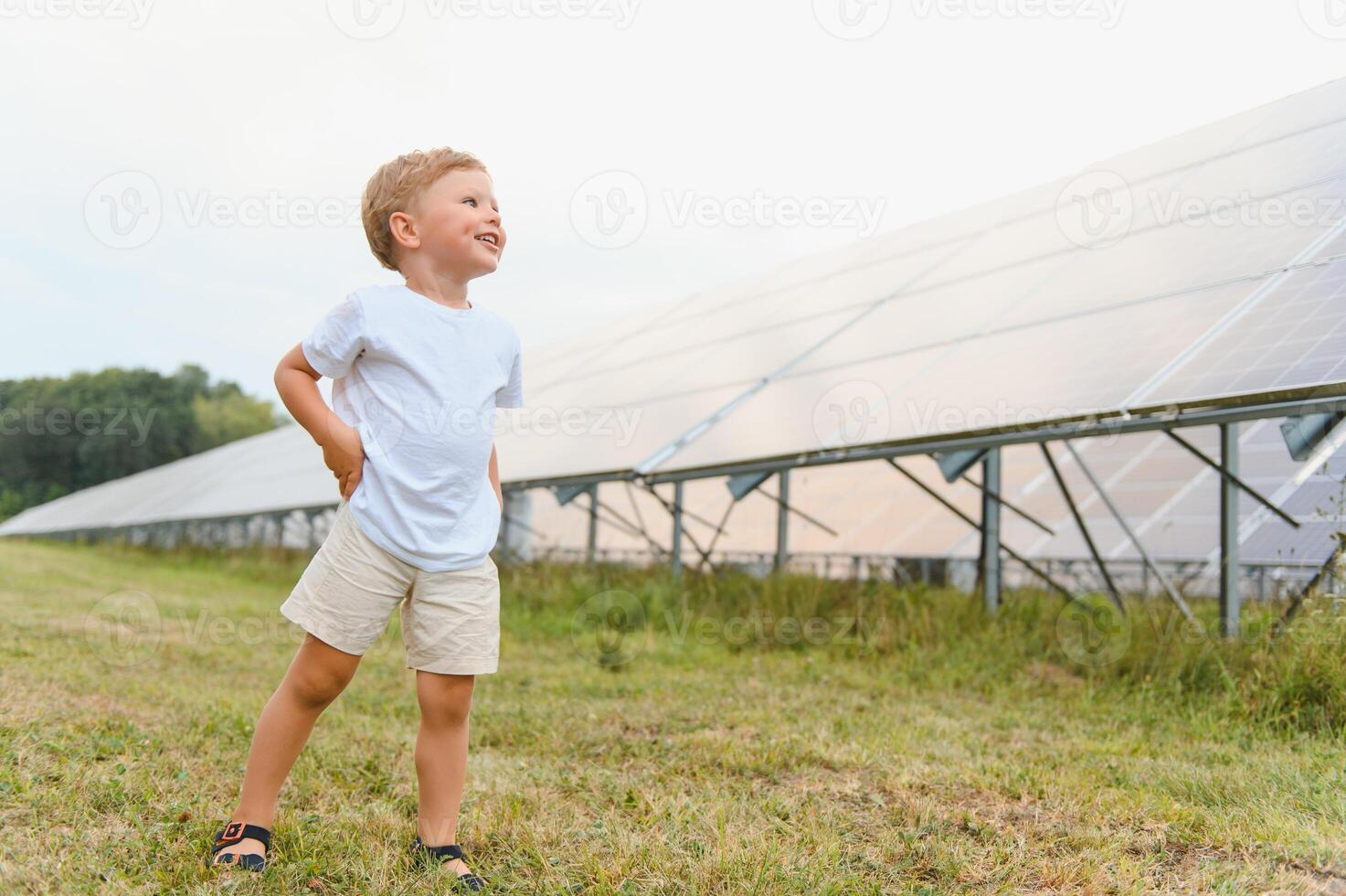 A little boy is having fun near the solar panels. The concept of solar energy. photo