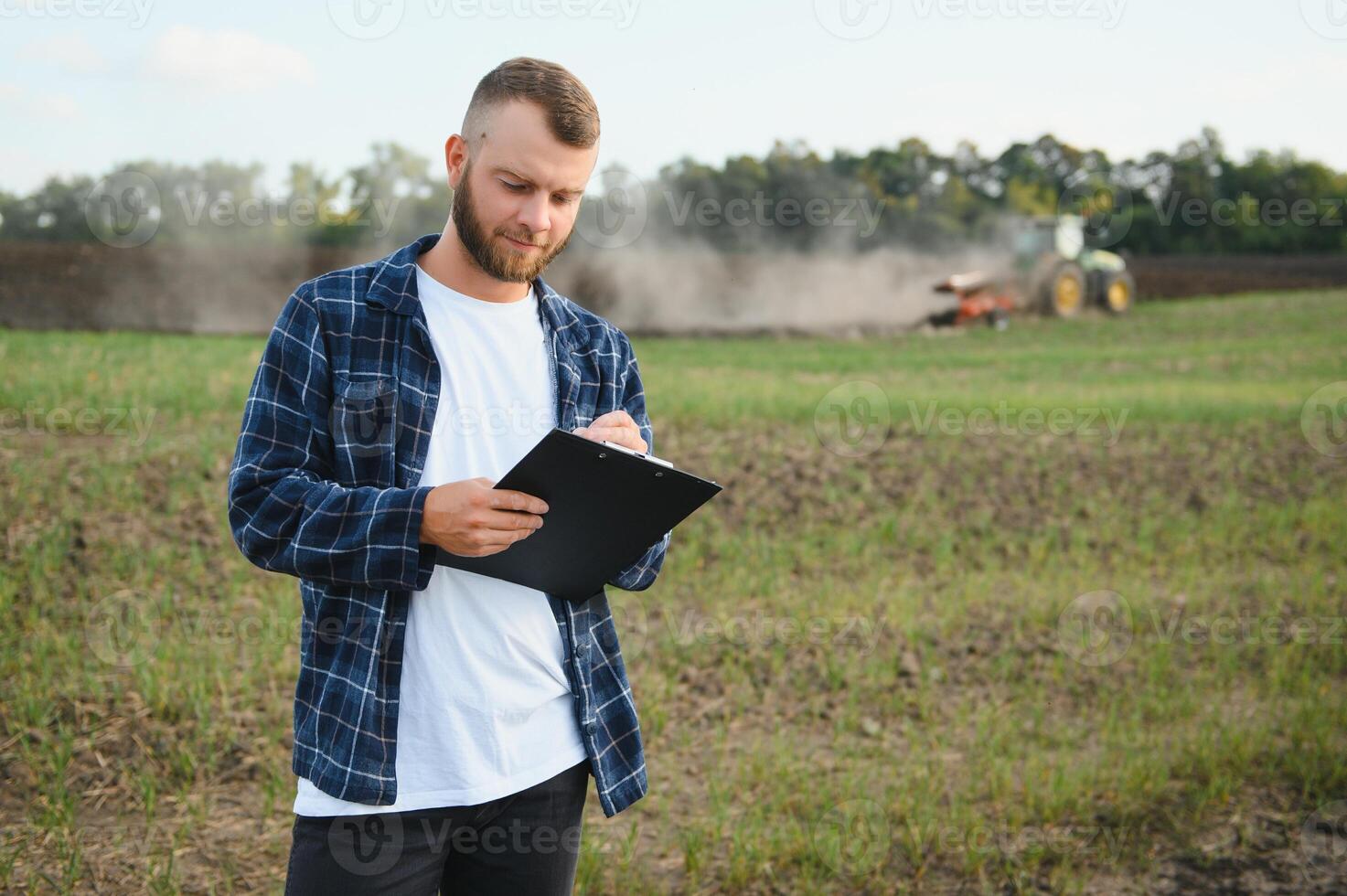 Agriculture. farmer working in a field in the background tractor plows ground in a field of wheat. farming agriculture concept. business farmer in the field photo