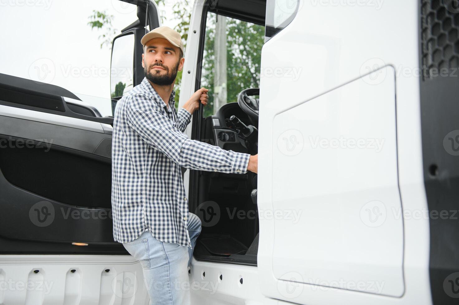 Truck driver climbing into cab of semi-truck photo