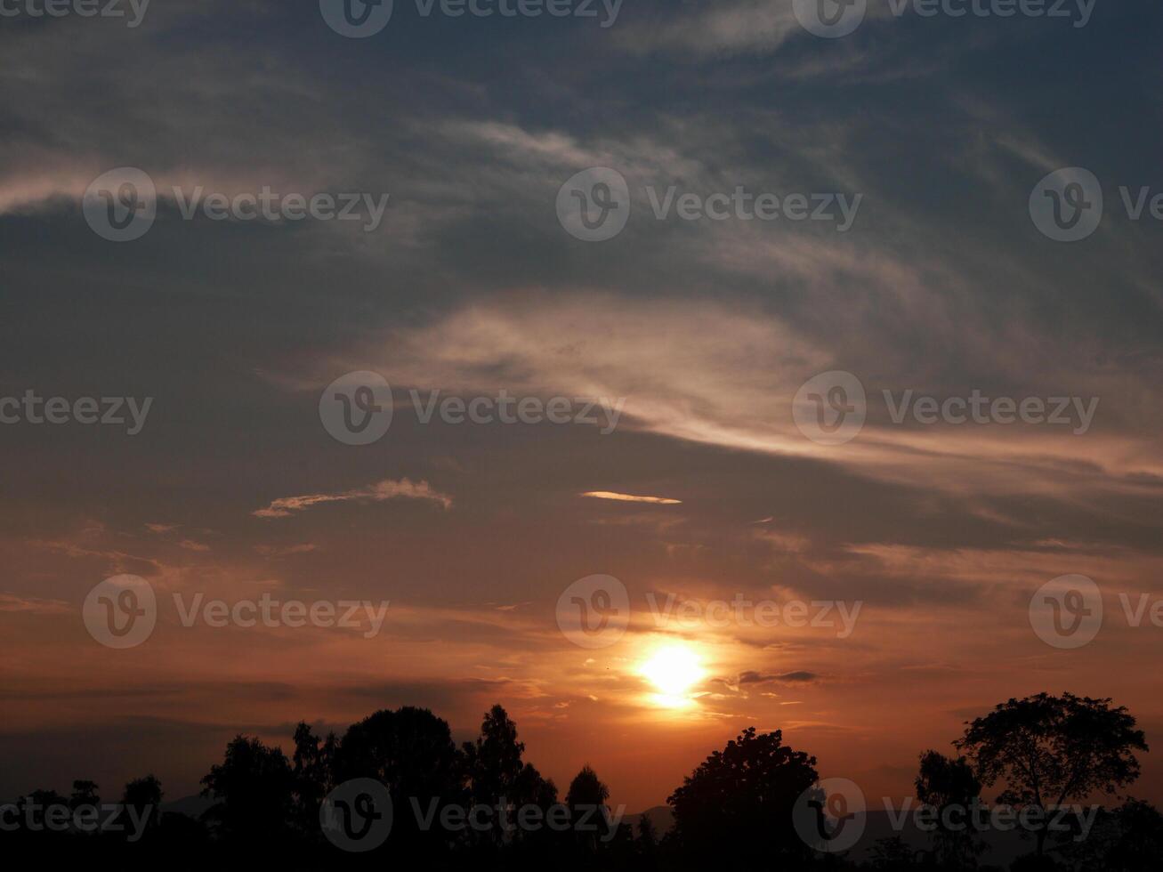 Spectacular sunset over, orange sun rising up over the horizon photo