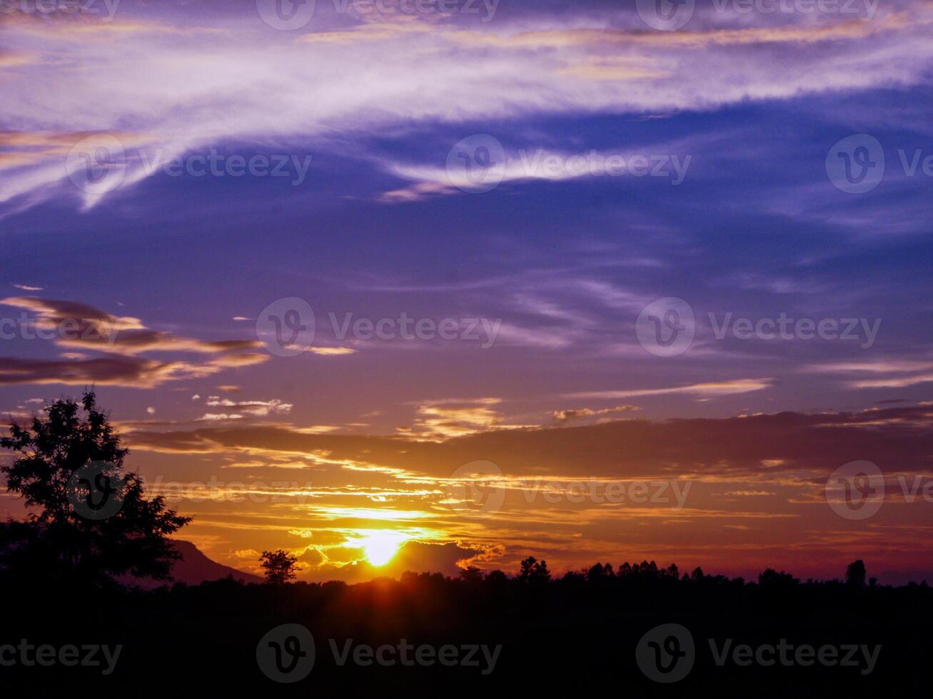 Spectacular sunset over, orange sun rising up over the horizon photo