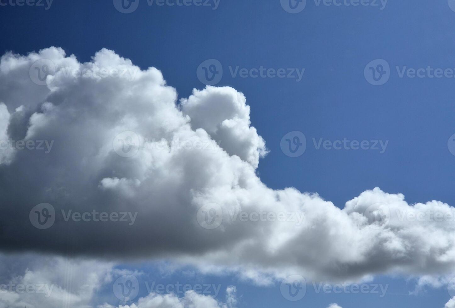 White fluffy cumulus clouds background. Summer clouds in the blue sky photo