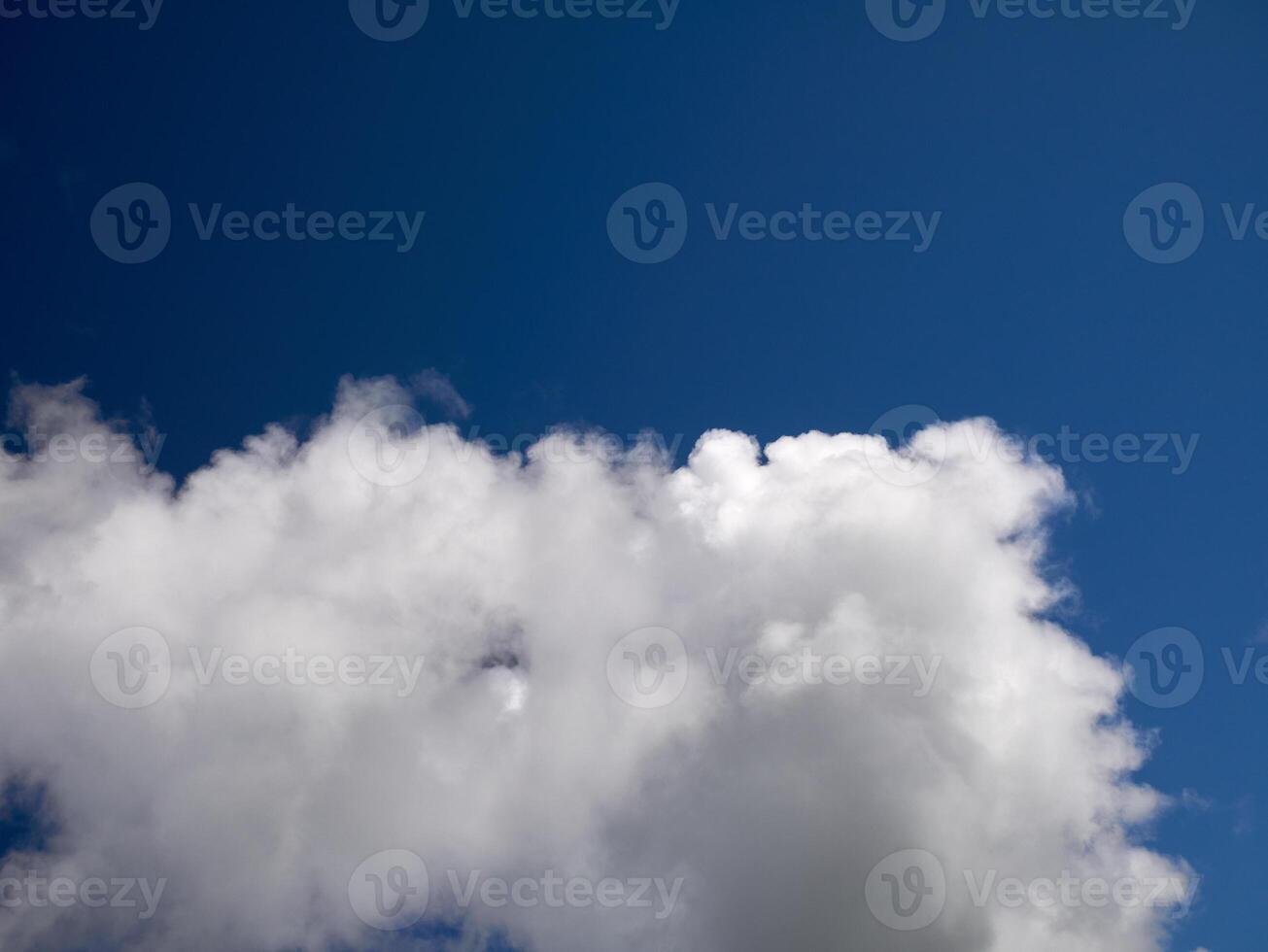 White cumulus clouds in the deep blue summer sky. Fluffy clouds background photo